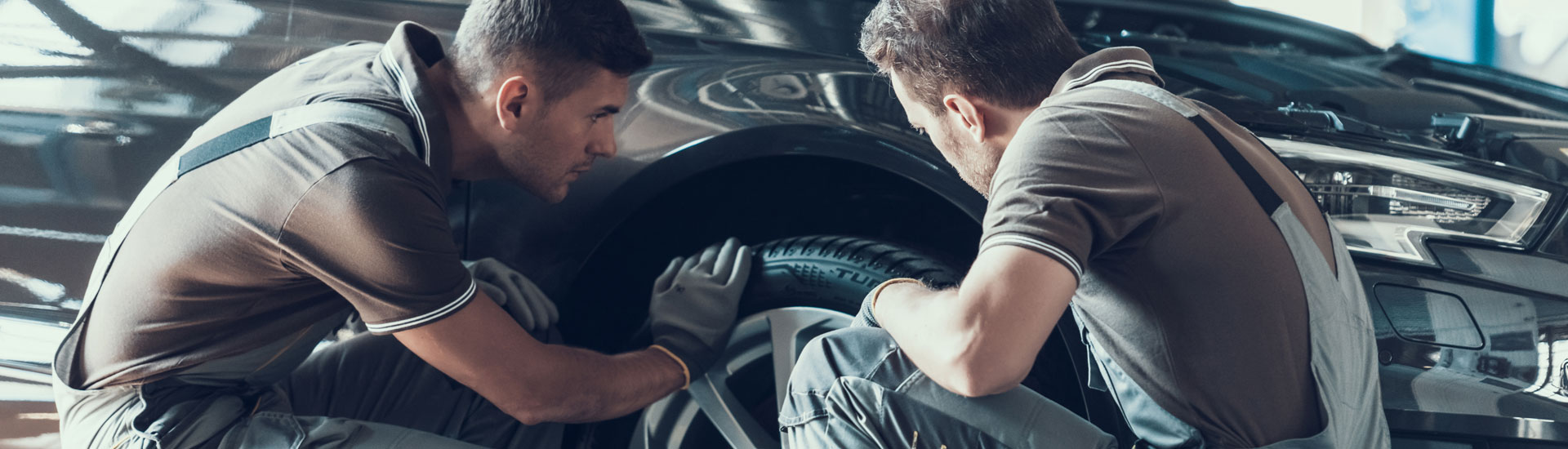 Mechanics Checking Car Wheel Bearings